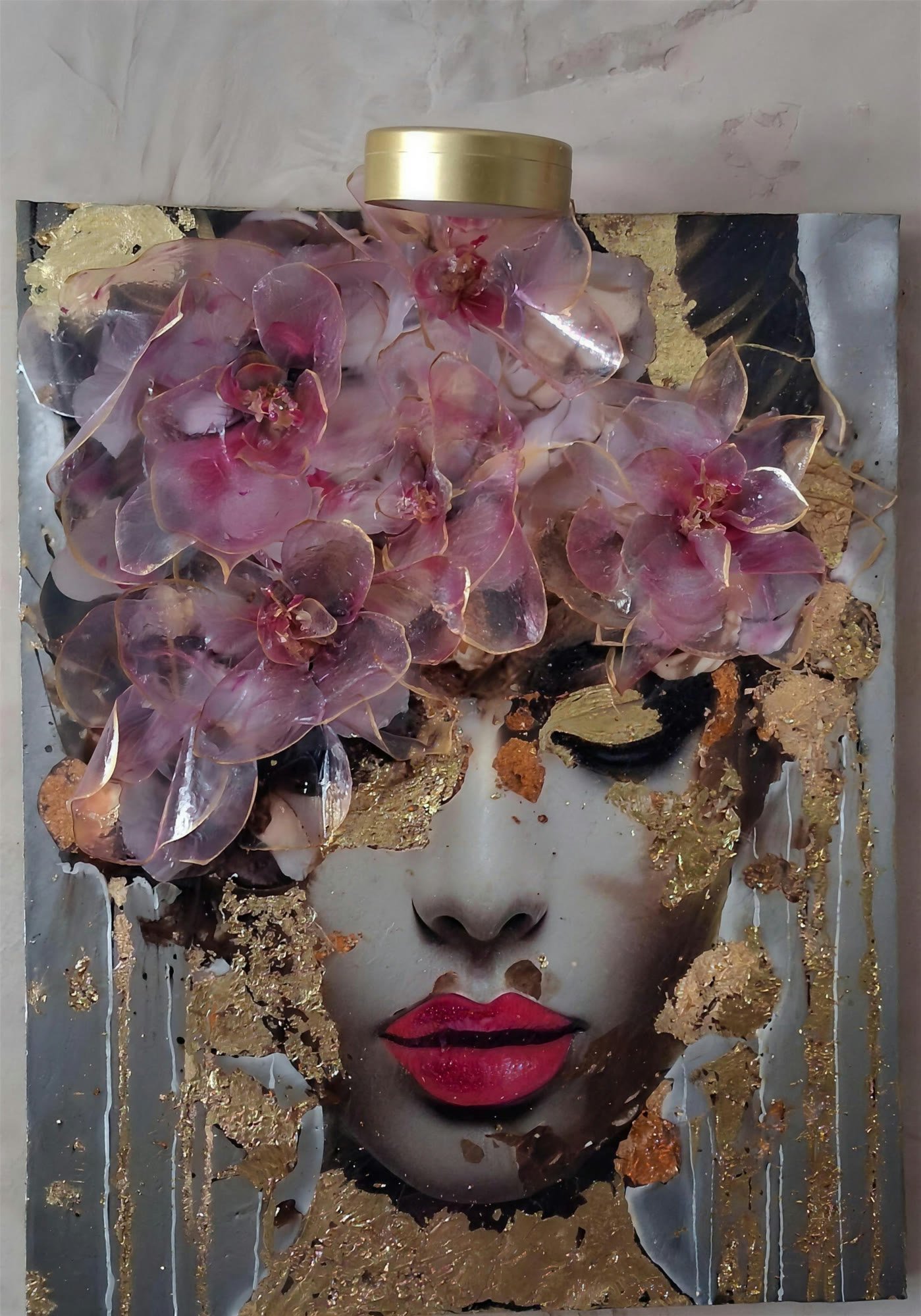 Orchidée Dorée, résine, feuille d'or et fleurs stabilisées sur toile : un visage voilé d'orchidées en relief, sous des coulées de feuille d'or et de résine.